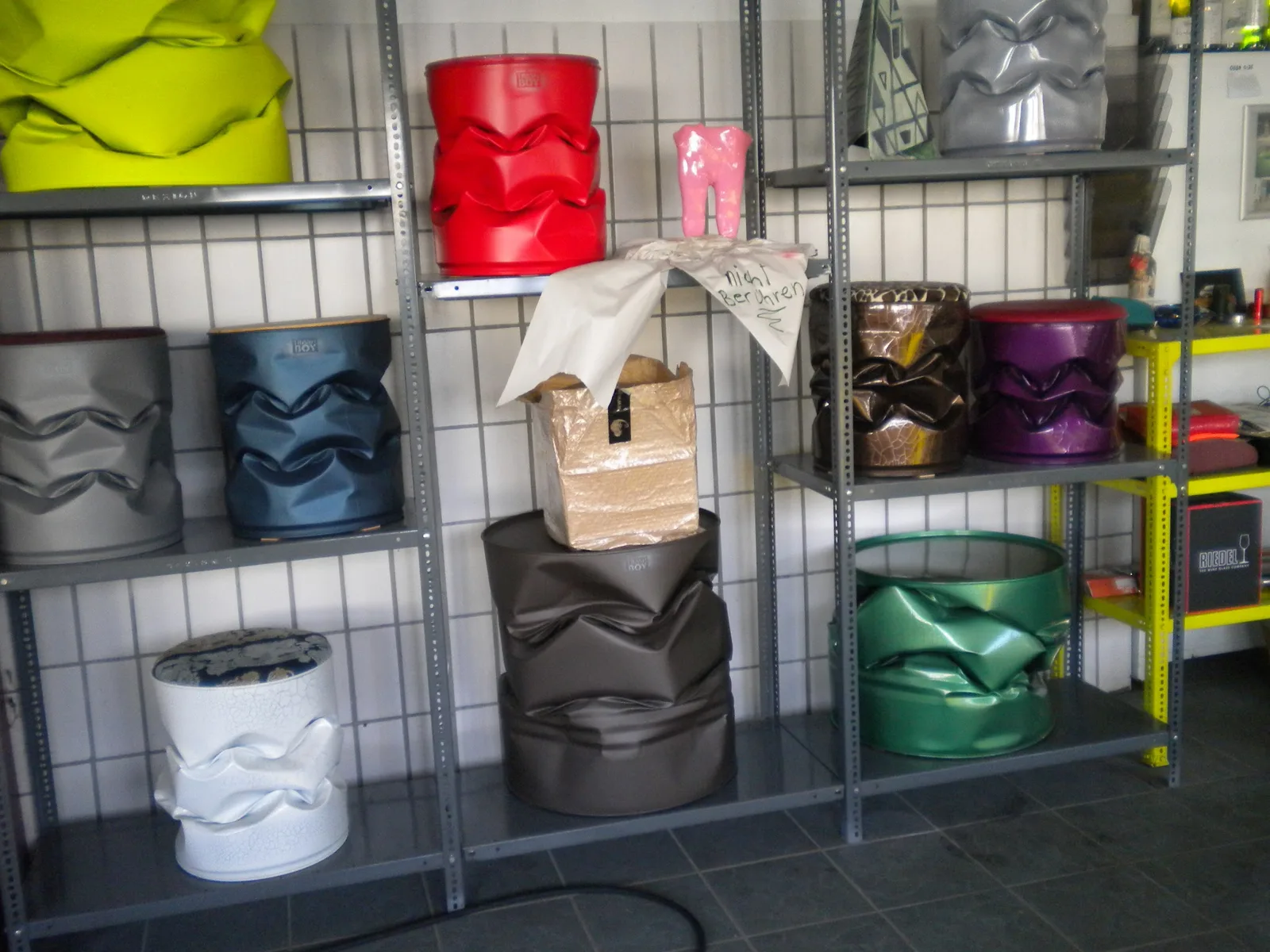 Regal mit lackierten Design-Objekten in vielen Farben, glänzend, metallic und mit Krakelee-Oberfläche